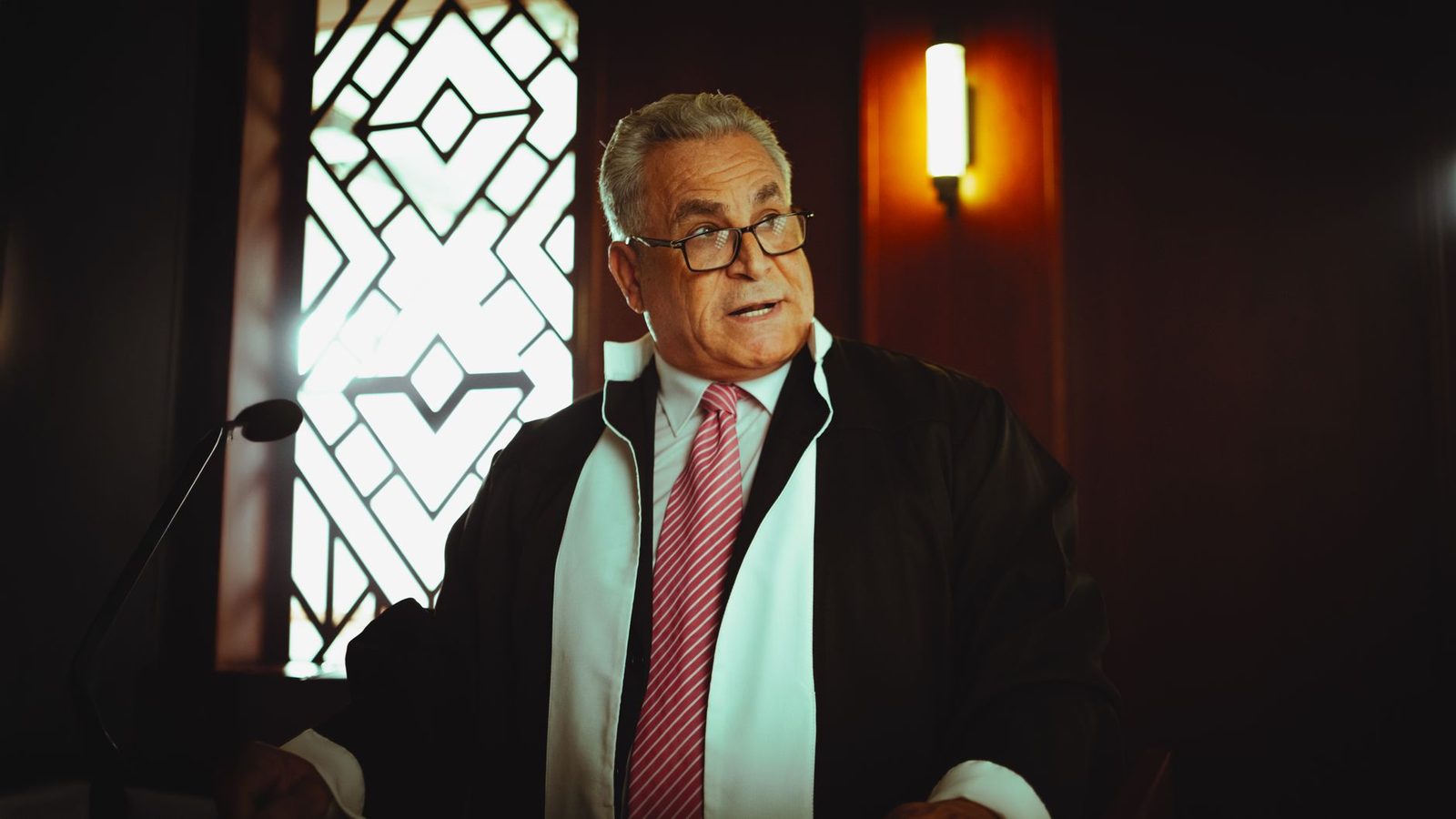 A judge in traditional attire presides over a courtroom in Baghdad, Iraq.