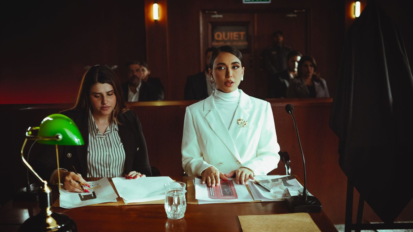 Female attorneys reviewing legal documents in a courtroom.
