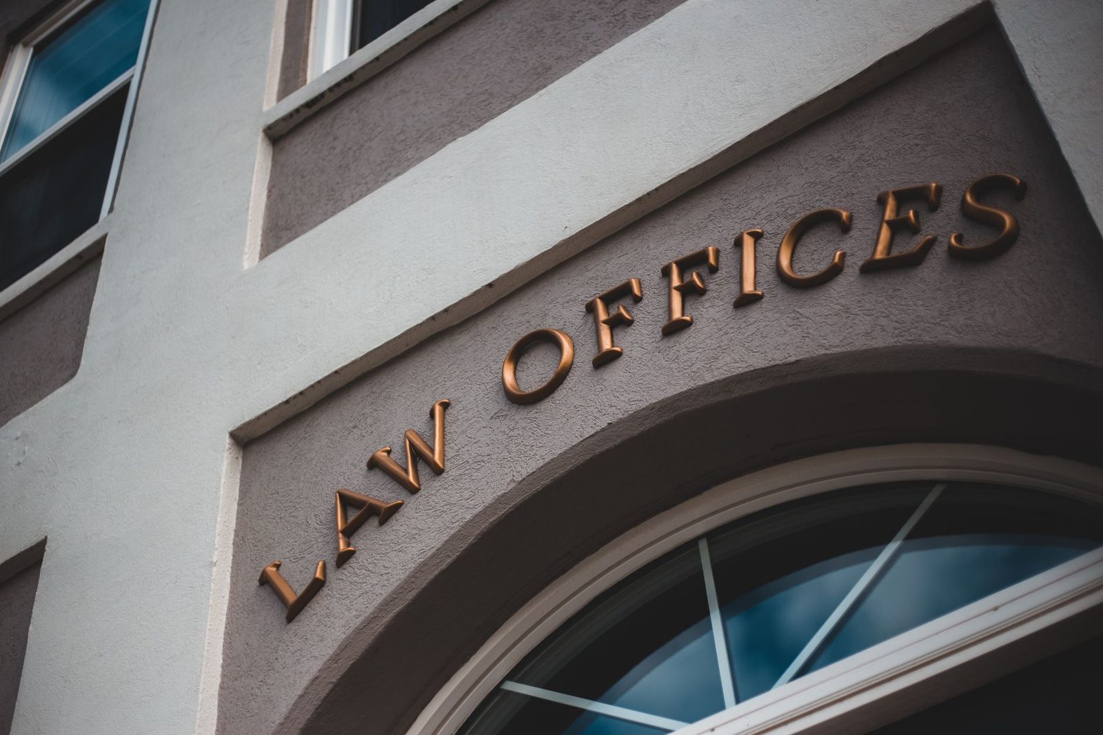 Modern law office building with arched entrance and elegant facade.