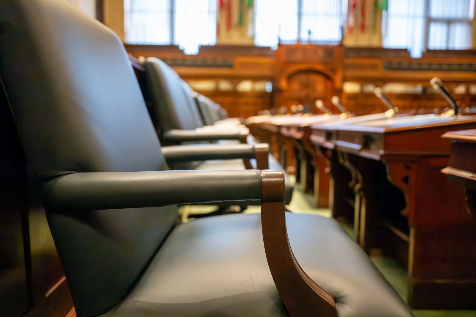 Sala de tribunal con sillas de cuero y escritorios de madera que transmiten autoridad legal.