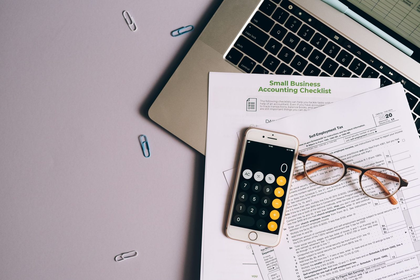 Tax form, phone, and glasses arranged on a desk workspace.