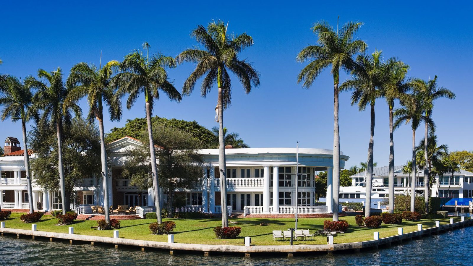 Waterfront mansion with palm trees in Fort Lauderdale, Florida.