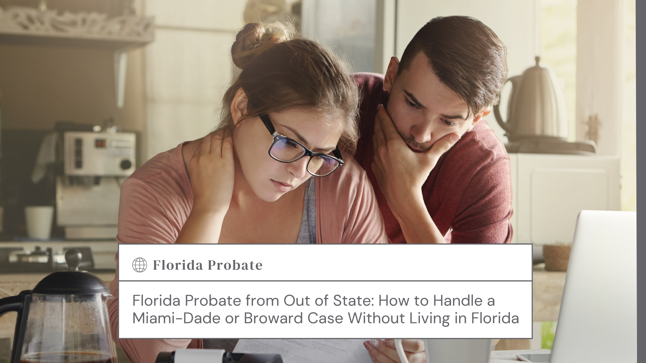 Couple sits at a kitchen counter, reviewing papers and looking thoughtful.