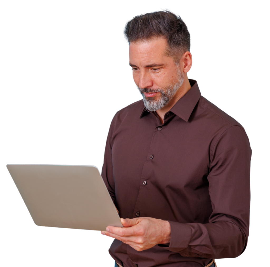Man in a brown shirt holds and looks at a silver laptop screen.