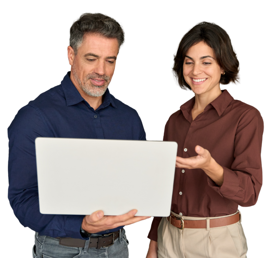 Two professionals, a man and a woman, look at a silver laptop held by the man on their work discussion side by side in a casual office setting behind them (no background).